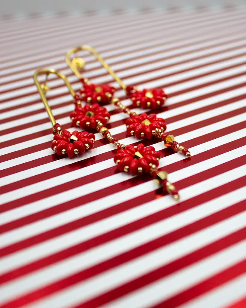 Czerwone długie kolczyki wykonane w technice haftu koralikowego. Delikatne trzy gwiazdki zwieńczone złotym biglem ze stali szlachetnej.